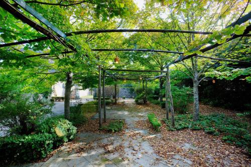a garden with a metal canopy with trees and a walkway at Tenuta Sant'Andrea in Muro Leccese