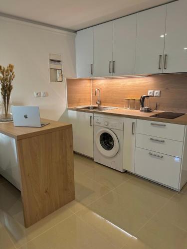 une cuisine avec un lave-linge et un ordinateur portable sur un comptoir dans l'établissement Studio Moderne et Spacieux, à Draveil