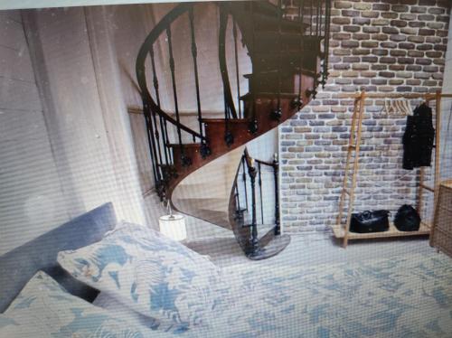 - un escalier en colimaçon dans le salon doté d'un canapé dans l'établissement La terrasse du champ clos, à Dinan