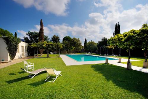 um quintal com duas cadeiras e uma piscina em Tenuta Sant'Andrea em Muro Leccese