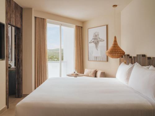 a bedroom with a large bed with a large window at Hyde Ibiza in Cala Llonga