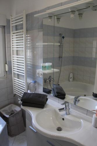 a bathroom with a sink and a mirror and a tub at Mostar House in Mostar