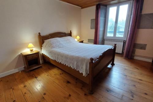 a bedroom with a bed and two tables with lamps at Grand gite 12 personnes proche du Lioran in Thiézac