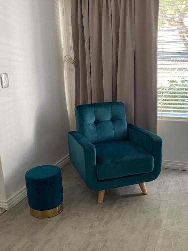 a blue chair and a stool in a room at Bed and Breakfast Villa Livadia in Cape Town