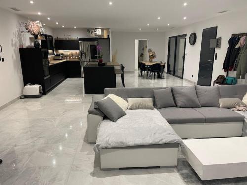 a living room with a couch and a kitchen at Magnifique villa proche ruoms vallon pont darc in Grospierres