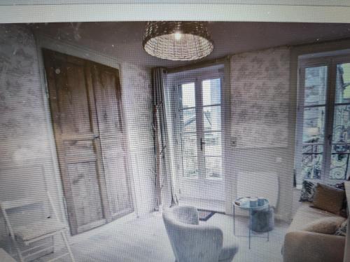 un salon avec un canapé, des chaises et un lustre dans l'établissement La terrasse du champ clos, à Dinan