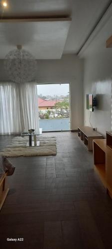a large bedroom with a large bed and a large window at Kim's Apartment in Takoradi