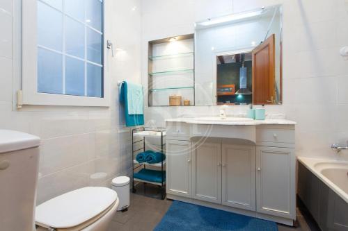 Un baño blanco con lavabo e inodoro. en Tranquilo y luminoso apartamento en el Eixample, en Barcelona