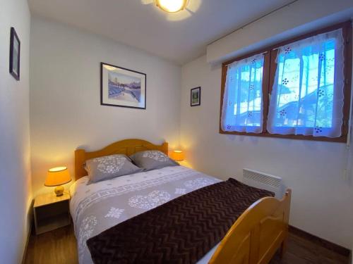 une chambre avec un lit avec deux lampes et une fenêtre dans l'établissement Iris 1 appartement T3 proche du Linga - Multipass inclu, à Châtel