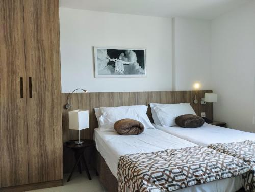a bedroom with two beds with pillows on them at Terra Hospedagem soho conforto e aconchego in Campos dos Goytacazes