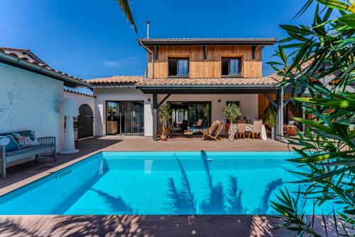 une villa avec piscine devant une maison dans l'établissement Villa avec Piscine La Teste de Buch, à La Teste-de-Buch