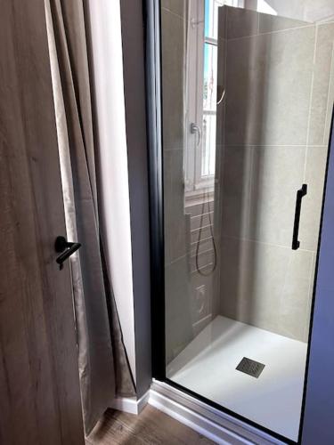 une douche avec une porte vitrée dans une salle de bain dans l'établissement Le Vernet - Centre historique, à Avignon