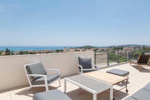 d'un balcon avec des chaises et des tables offrant une vue sur l'océan. dans l'établissement Les Cigales, à Antibes