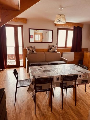 un salon avec une table et un canapé dans l'établissement Duplex 6 personnes les Balcons de Recoin, à Chamrousse
