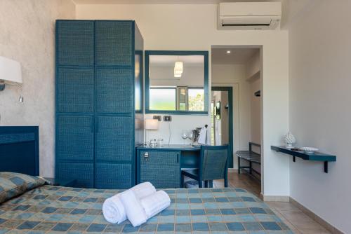 a bedroom with a bed with two towels on it at Hotel Baia Del Capitano in Cefalù