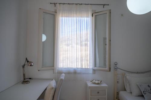 a white room with a bed and a window at ‘Sophie’s Villa’ in Naxos Chora