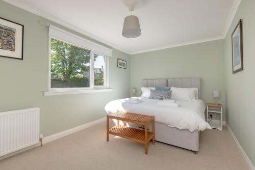 a white bedroom with a bed and a window at Westerham in North Berwick