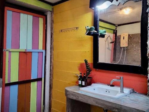 a bathroom with a sink and a colorful wall at Leaf House Bungalows in Ko Lanta