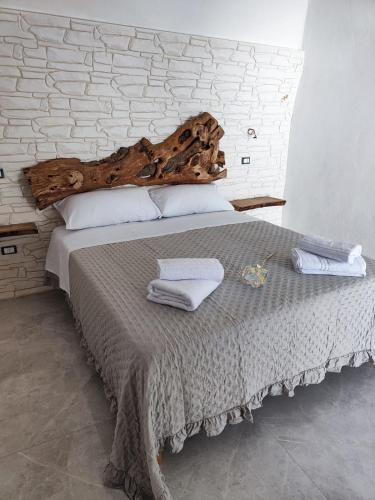 a bedroom with a large bed with a wooden headboard at RIZZO RELAX Residence SALENTO in Capilungo