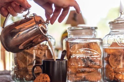 a person is pouring coffee into a cup at Kruger Untamed - Tshokwane River Camp in Skukuza