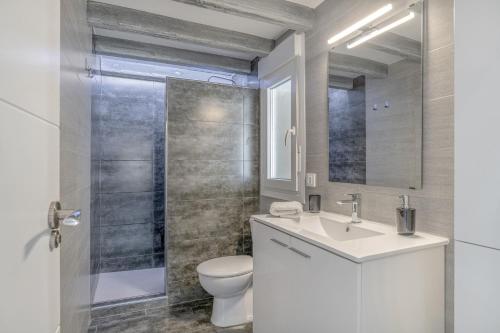 Un baño con inodoro, lavabo y ducha. en Casa El Trebol, en Vejer de la Frontera