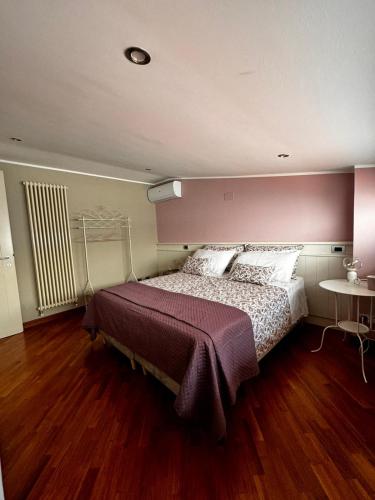 a bedroom with a large bed with a wooden floor at Formia Bellevue in Formia