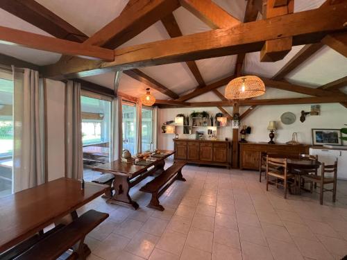 une salle à manger avec des tables en bois et une cuisine dans l'établissement L'Oustaou Castellane, à Castellane