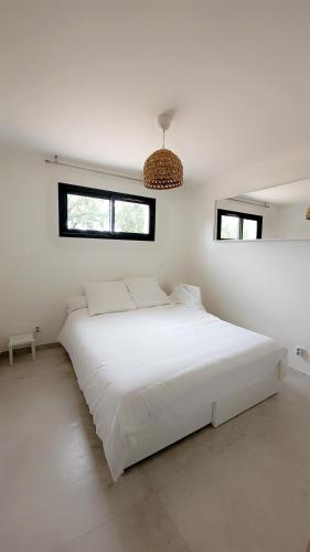 - une chambre blanche avec un lit blanc et 2 fenêtres dans l'établissement Villa raffinée, piscine, jardin, proche Cassis et Marseille, à Aubagne