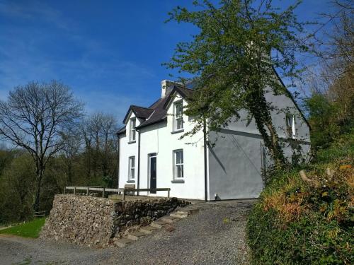 a large white house with a large garage at Farthings Hook Mill Holiday Cottage in Henrys Moat