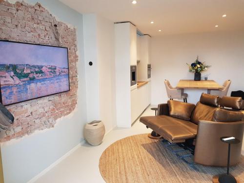 a living room with a couch and a brick wall at Beach House Bonna - free parking & bikes in Scheveningen