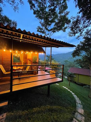 Un banco de madera frente a una casa con vista. en Cabañas Wilú, en Nocaima