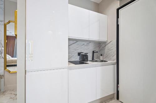 une cuisine avec des armoires blanches et un évier dans l'établissement Nice Renting - 8FRANCE - Luxury & Comfort Love Room Suite Jacuzzi Massena, à Nice