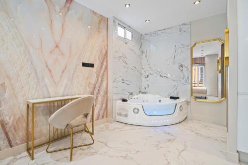 La salle de bains est pourvue d'une baignoire et d'un miroir. dans l'établissement Nice Renting - 8FRANCE - Luxury & Comfort Love Room Suite Jacuzzi Massena, à Nice