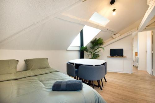 une chambre avec un lit, une table et une télévision dans l'établissement Le Cocon : studio en Hypercentre Cathédrale, à Amiens