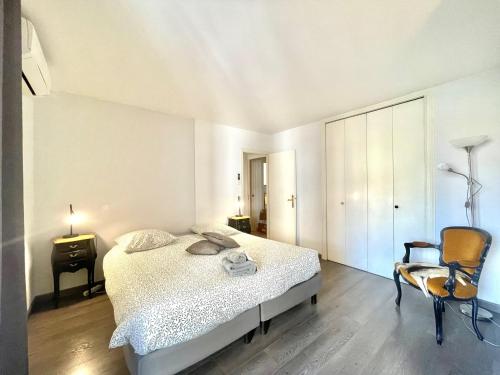 une chambre blanche avec un lit et une chaise dans l'établissement Cannes Center by Welcome to Cannes, à Cannes