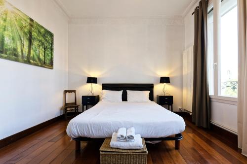 a bedroom with a bed and two shoes on a table at La Suite Joli Coeur - Appt type Ecole de Nancy in Nancy