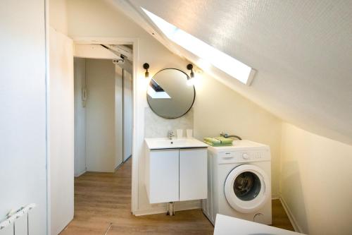 y baño con lavadora y espejo. en Le Cocon : studio en Hypercentre Cathédrale, en Amiens