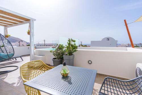 a table and chairs on a balcony with a view at SantoRossa Luxury Villas in Emporio Santorini