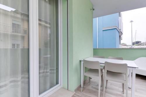 a dining room with a white table and chairs at Residence Diffuso Arcobaleno in Gabicce Mare