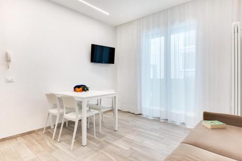 a white dining room with a white table and chairs at Residence Diffuso Arcobaleno in Gabicce Mare