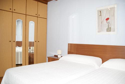 a bedroom with a white bed and wooden cabinets at Casa con patio en Nueva de Llanes - El Churru in Nueva de Llanes