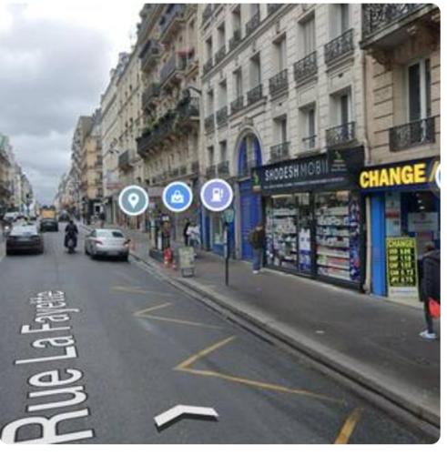 une rue avec des voitures garées sur le bord de la route dans l'établissement GRAND APPARTEMENT Paris 10, à Paris