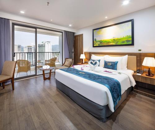 a hotel room with a large bed and a large window at Gonsala Hotel Nha Trang in Nha Trang