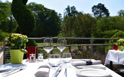 a table with wine glasses and a vase of flowers at Mondorf Parc Hotel & Spa in Mondorf-les-Bains