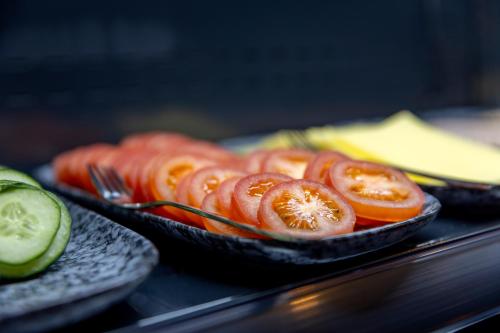 two plates of food with tomatoes and cucumbers at Tourist Inn One Amsterdam in Amsterdam