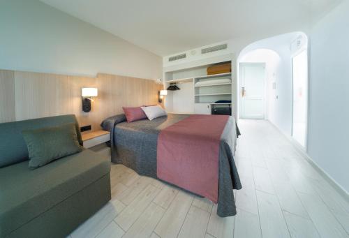 a hotel room with a bed and a couch at Hotel Calimera Fido Gardens in Cala d´Or