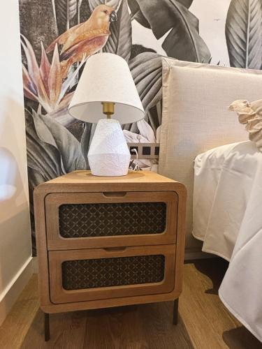 a lamp on a night stand next to a bed at Live home in Hervás