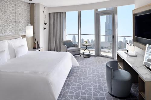 a hotel room with a large bed and a television at Kempinski Central Avenue Dubai in Dubai