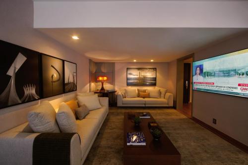 a living room with a couch and a flat screen tv at Kubitschek Plaza Hotel in Brasilia