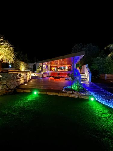 a house with a green lawn at night at La Pura Vida 34 in Pignan